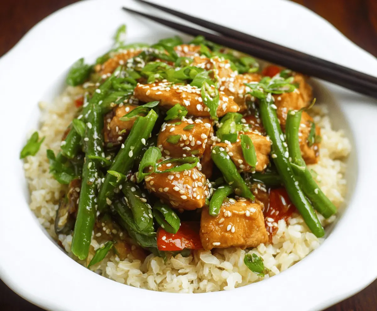 Sesame Chicken and Green Bean Stir-Fry dish with crispy chicken pieces, fresh green beans, and sesame seeds, served in a savory sauce.