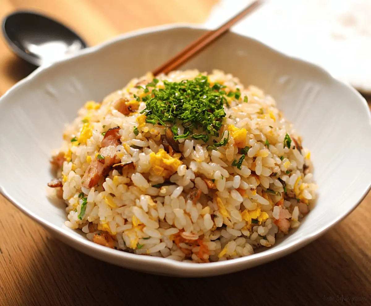 Delicious Japanese fried rice garnished with green onions and served in a bowl.