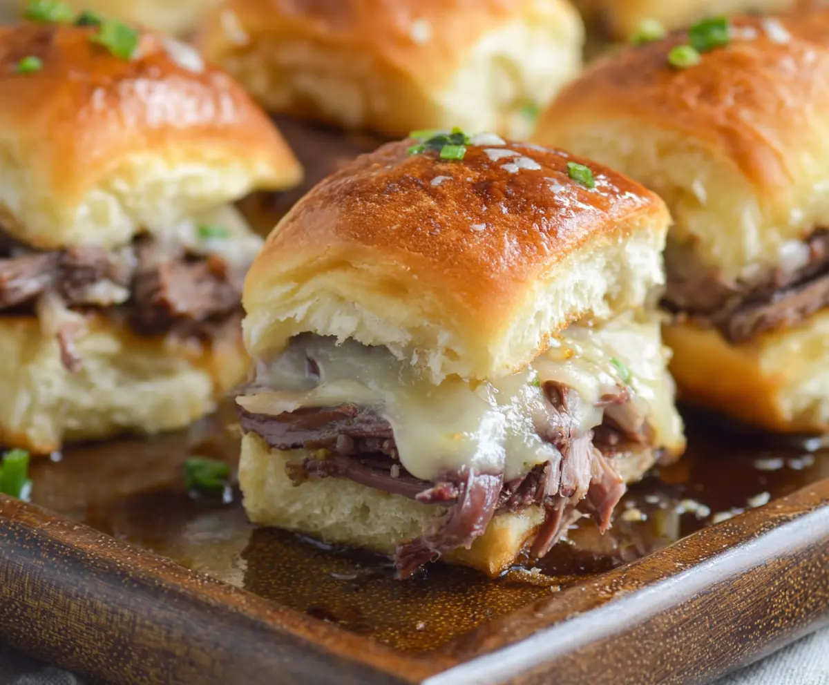 Delicious French Dip Sliders with tender roast beef and melted cheese in slider buns.